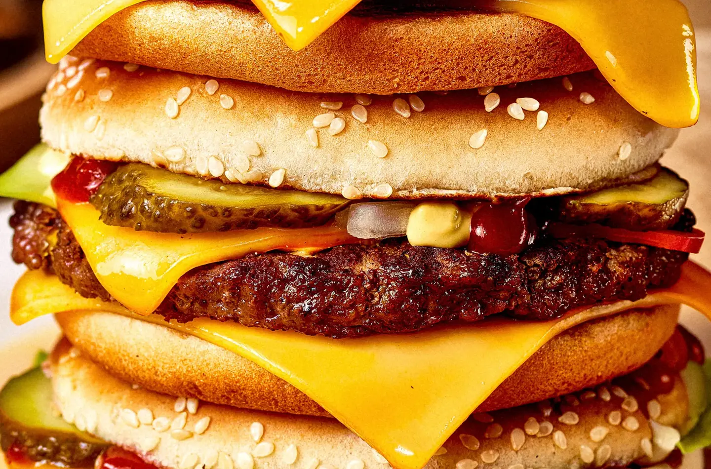 Extreme close-up of a flame-grilled cheeseburger with cheese, pickles, ketchup and mustard