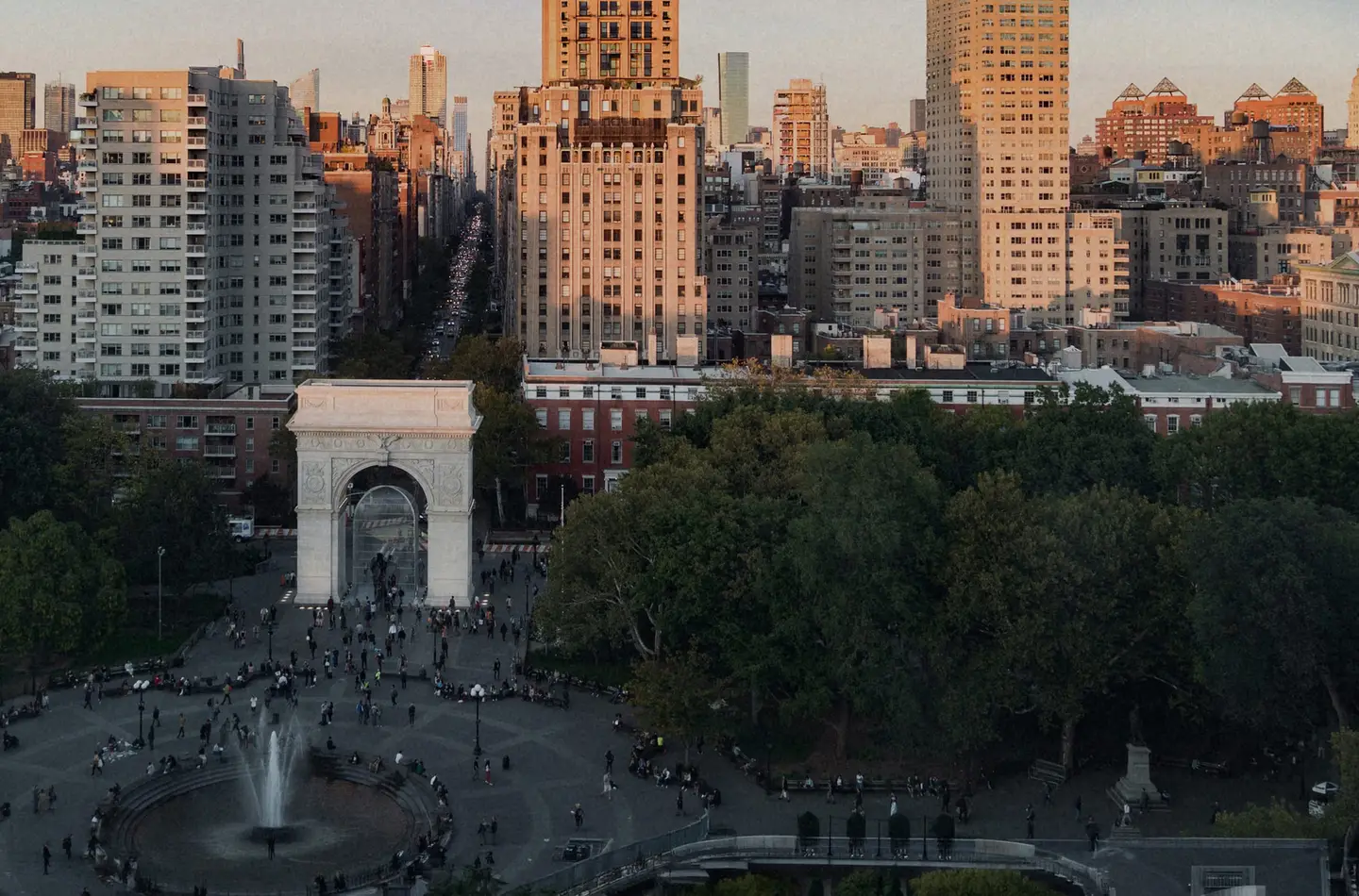 Aerial view of Washington Square Park, its arch and fountain framed by the Manhattan skyline