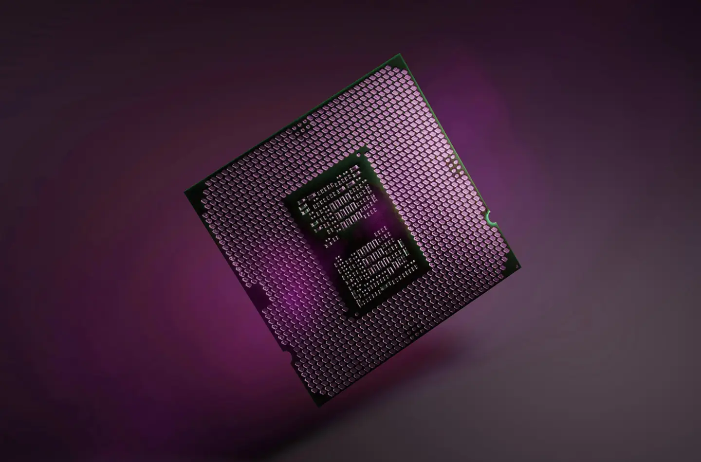 A Micron semiconductor chip lit by magenta and purple light against a dark background