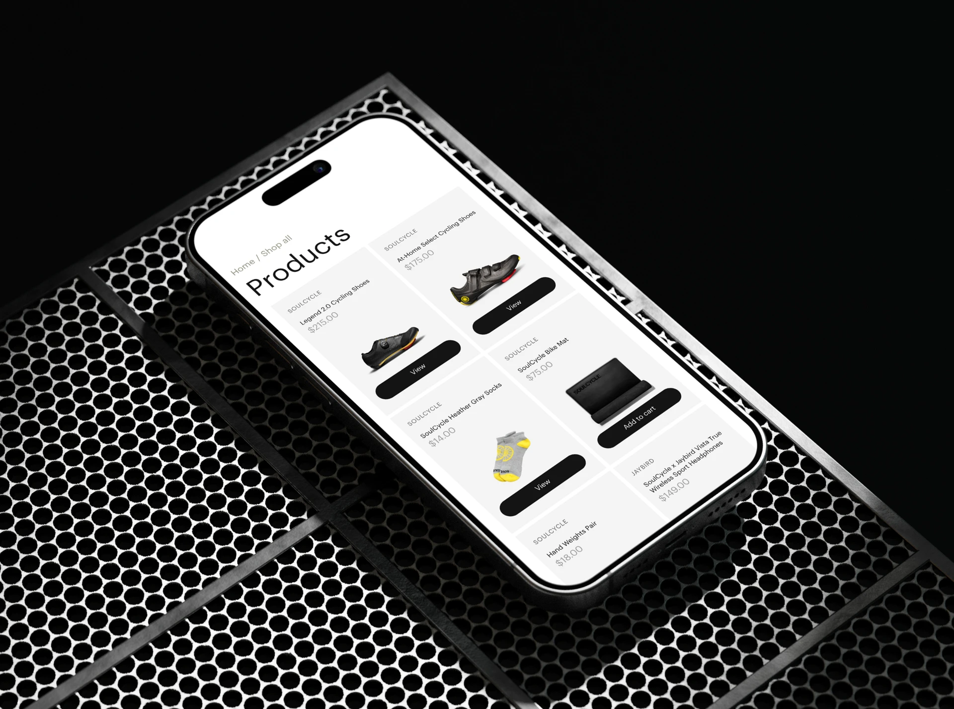 Phone on a black perforated surface showing the SoulCycle shop products page