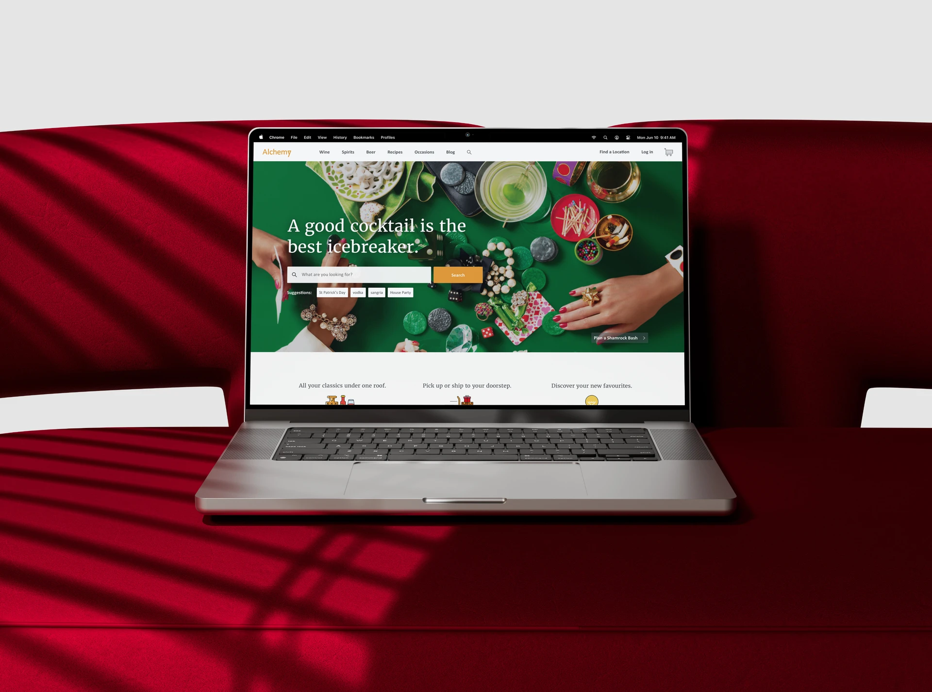 Laptop on a red couch showing the Alchemy spirits eCommerce homepage