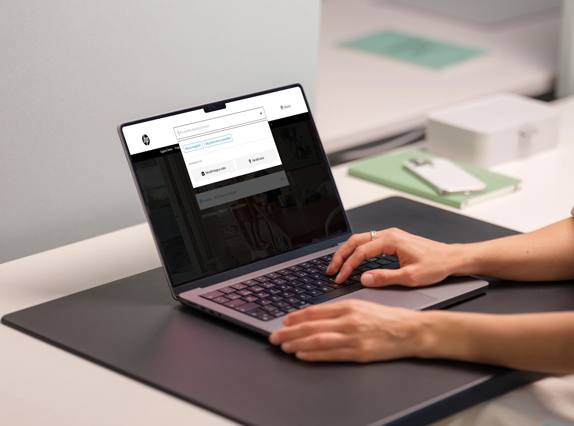 Hands typing on an HP laptop open to the HP support site