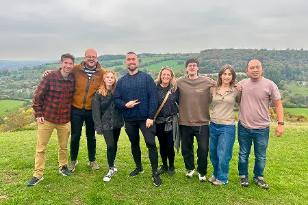 A Konrad team group photo standing together in a green field