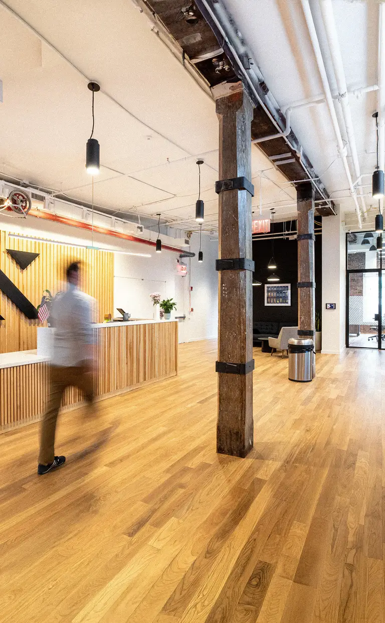 Konrad’s New York office reception, with a wood-slat wall and exposed timber column