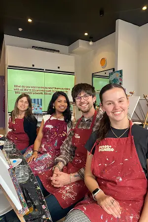 Two team members in aprons smiling during a cooking class