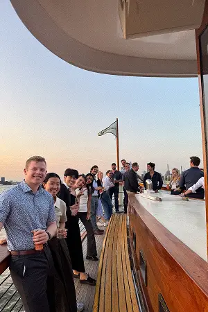 Konrad team members gathered at a rooftop railing at sunset