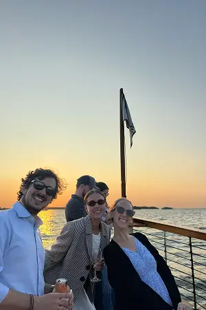 Konrad team members gathered at a railing overlooking the water at sunset