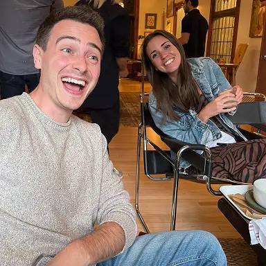 Two team members seated together and laughing