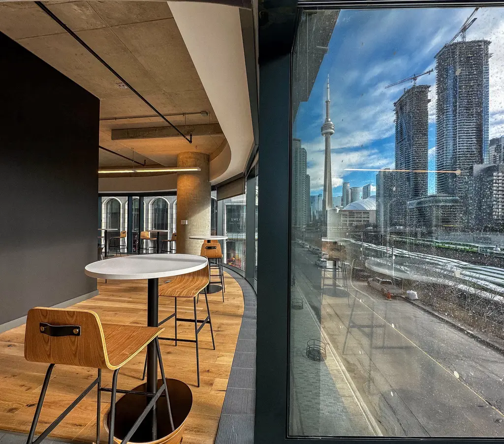 Konrad’s Toronto office lounge with bar seating and a window view of the CN Tower
