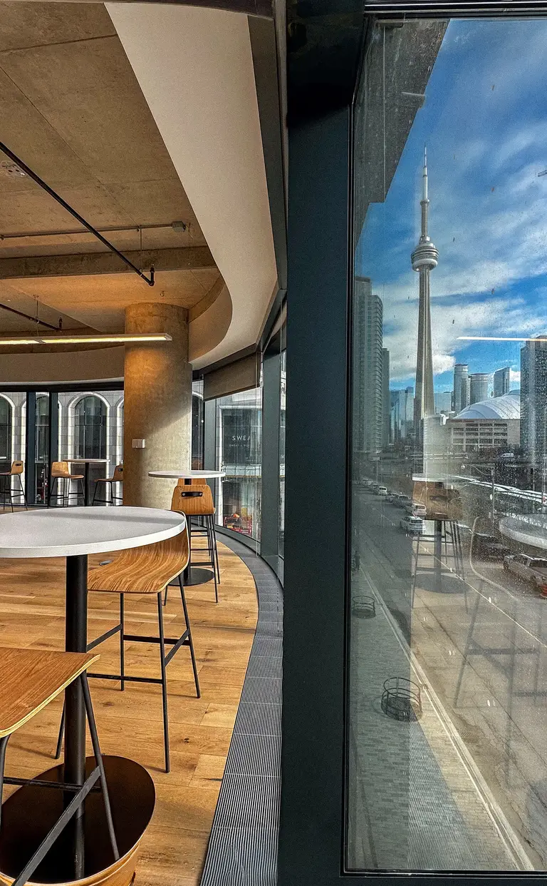 Konrad’s Toronto office lounge with bar seating and a window view of the CN Tower